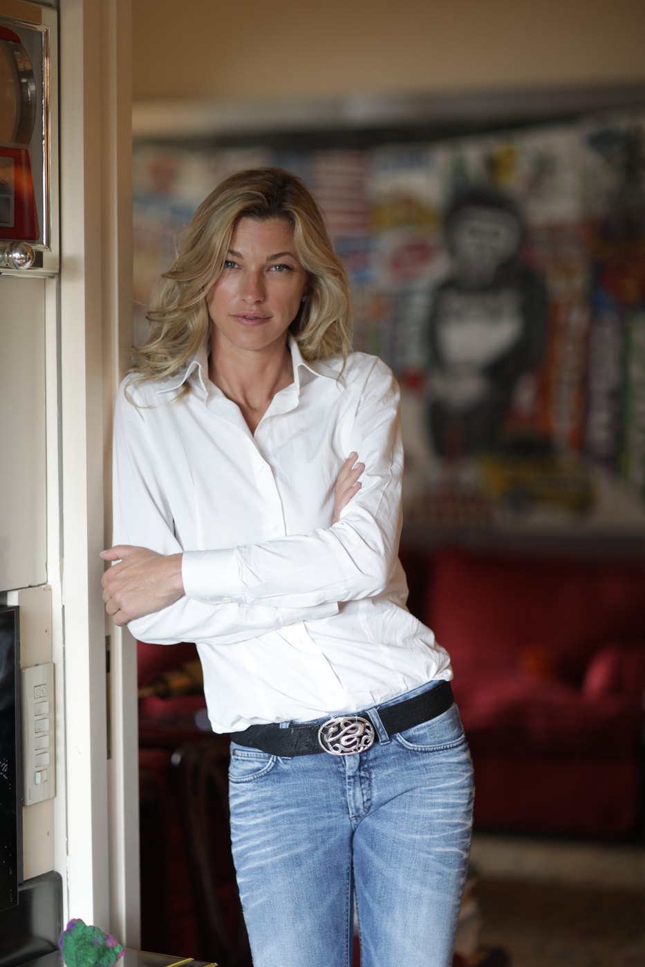 Nicole Junkermann standing in a white shirt beside a doorway in a bright room, a relaxed colour portrait