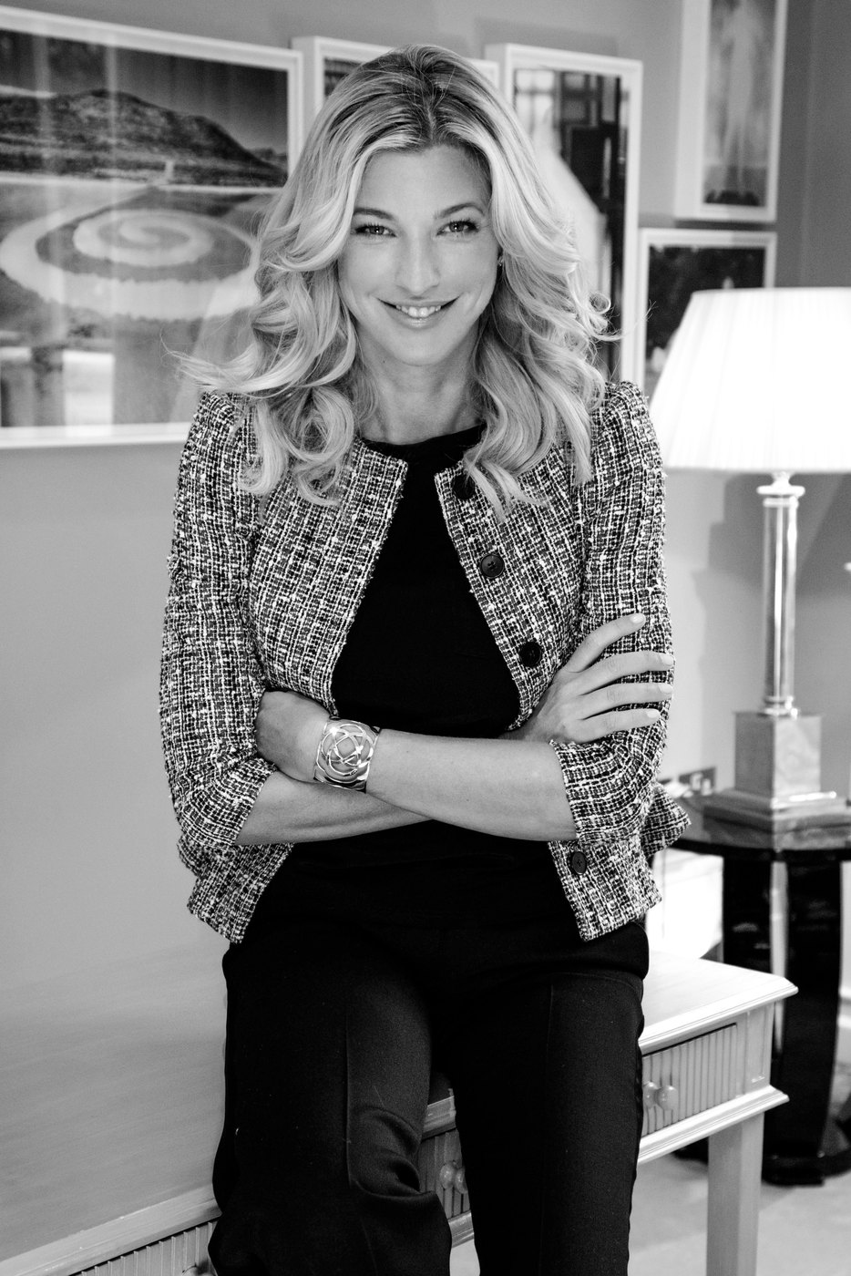 Nicole Junkermann smiling in a textured jacket in a bright room, a black-and-white editorial portrait