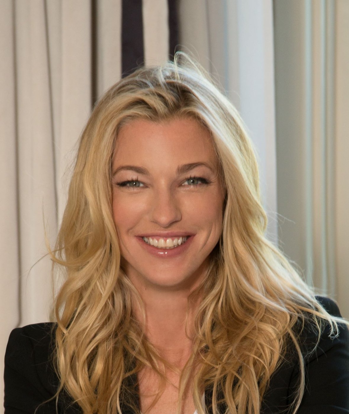 Nicole Junkermann smiling warmly in a bright room, a close colour portrait
